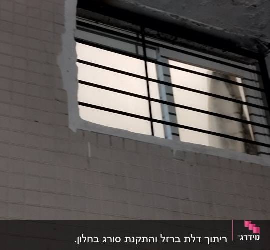 חלון עם סורגים במסגרת מתכת